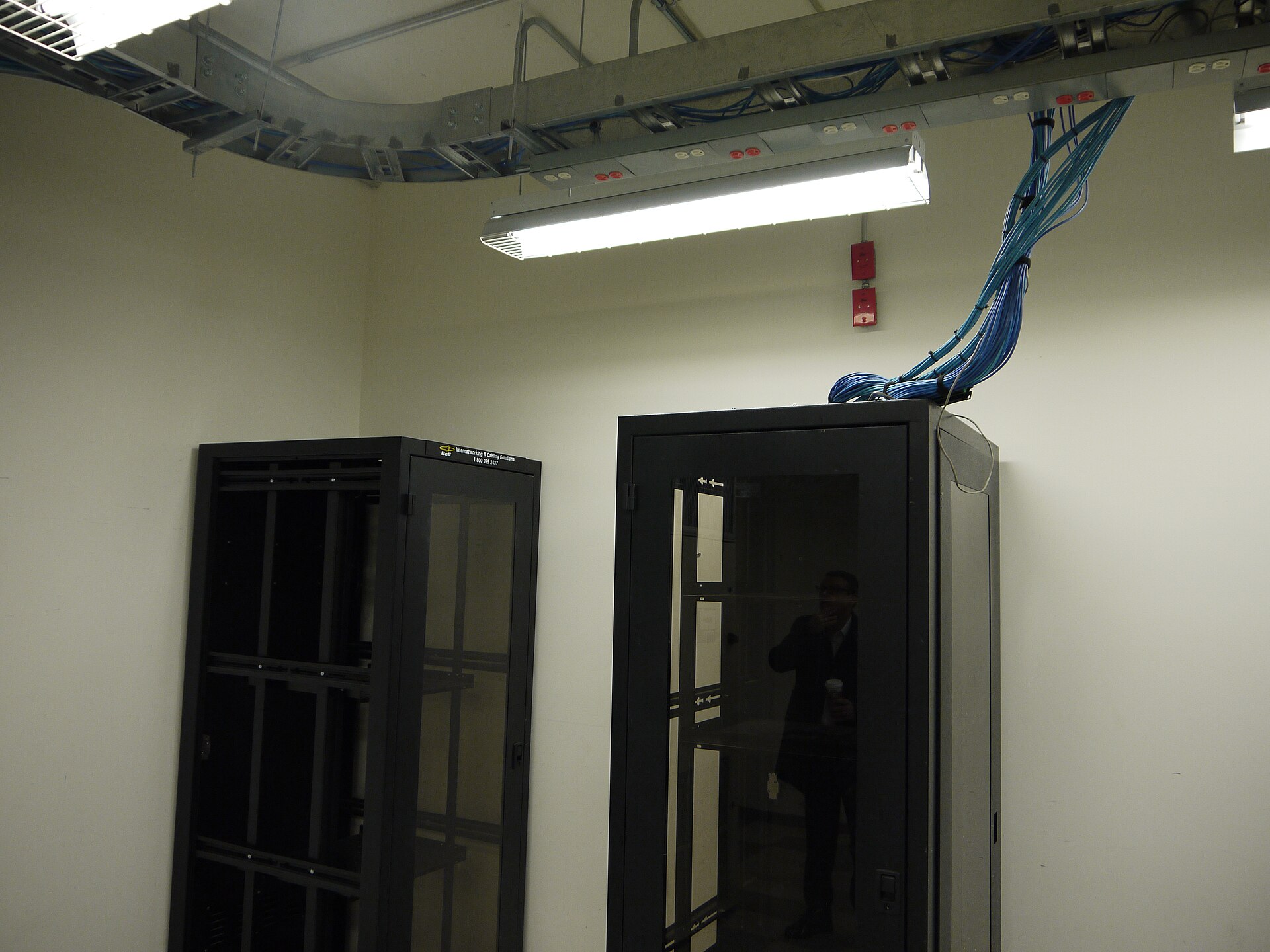Rows of racks and structured cabling inside a working data centre